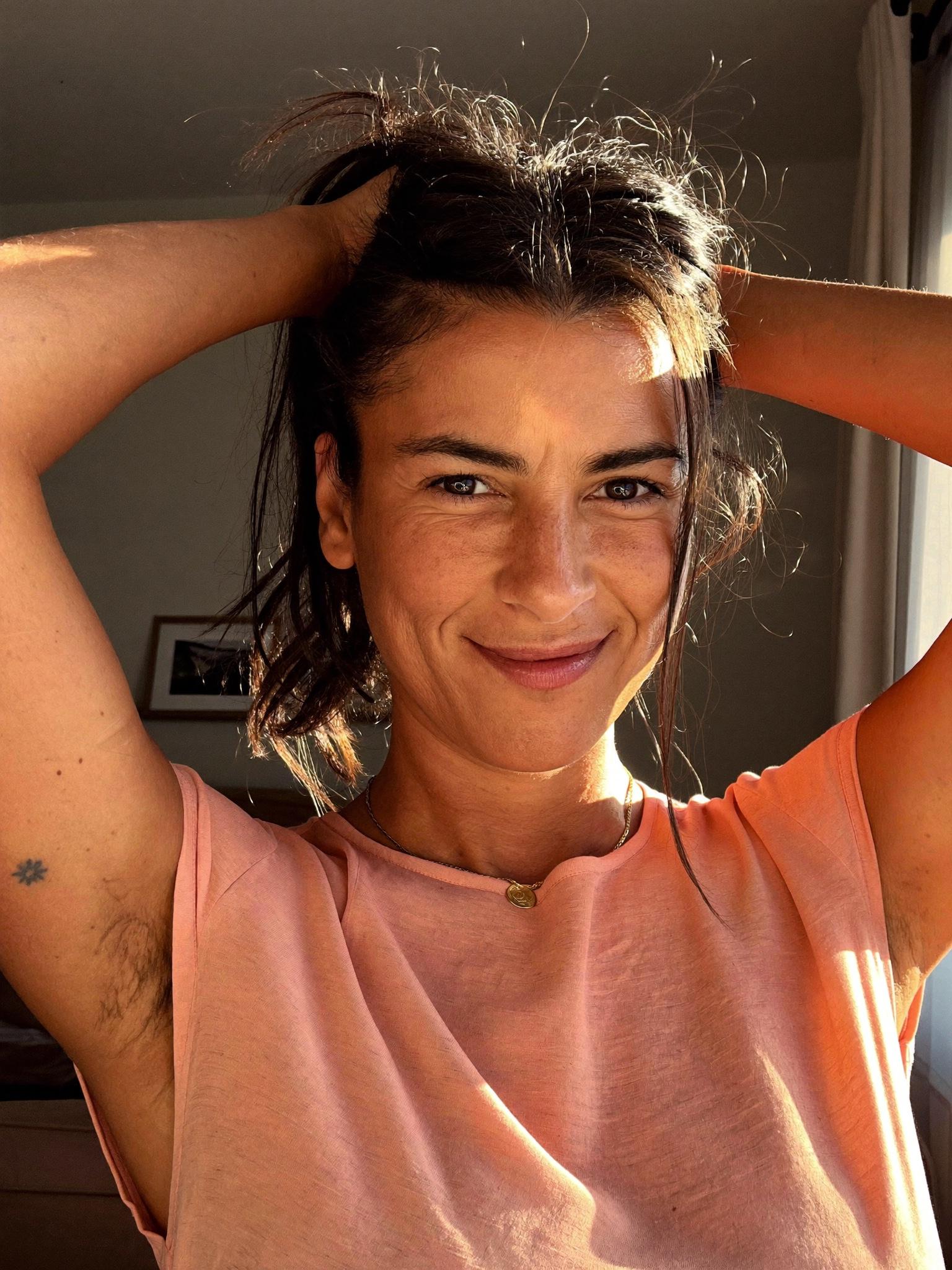 A Latina woman in her late thirties in a sunlit Phoenix living room.